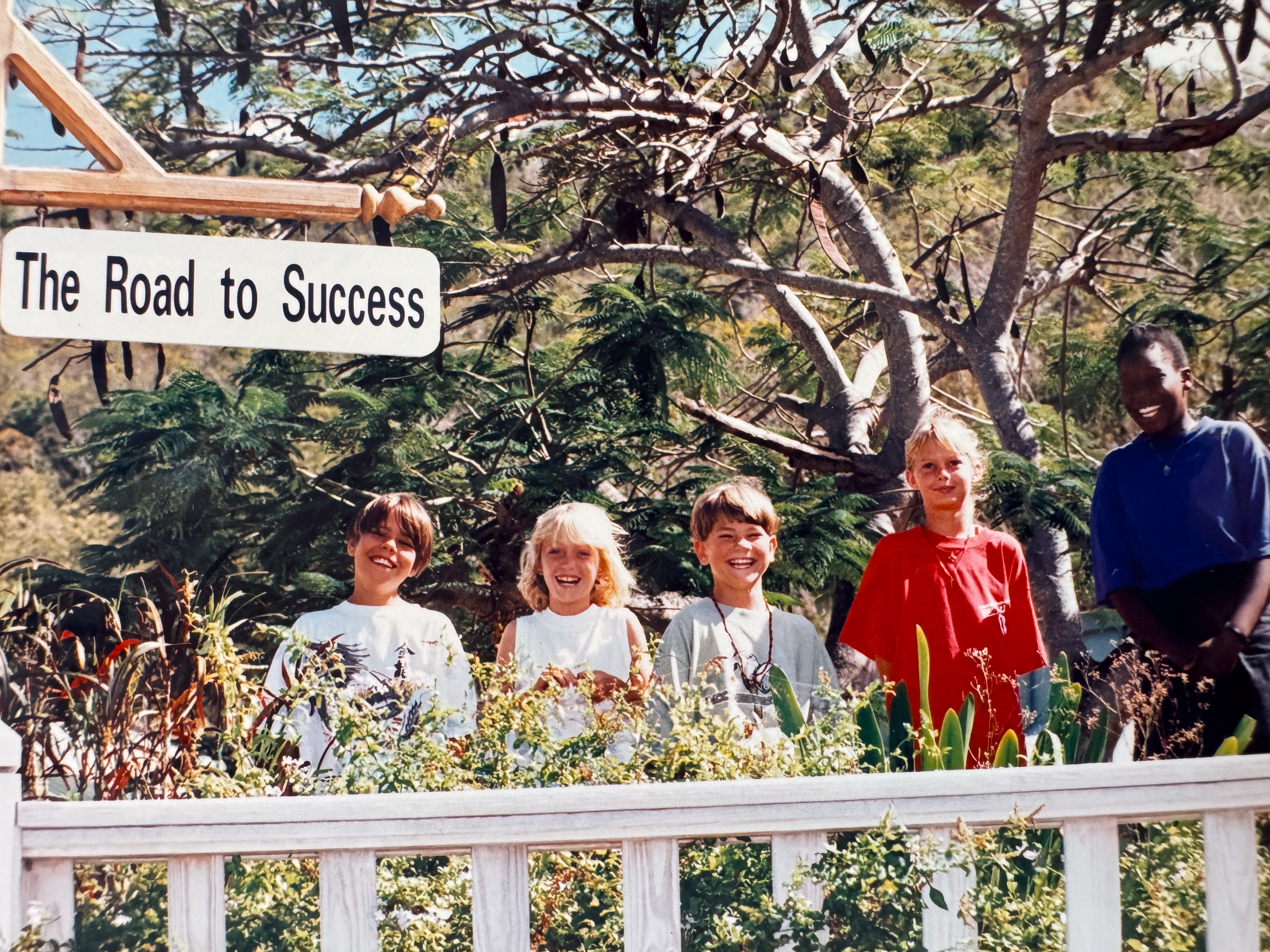 Antilles students smiling beneath a Road to Success sign