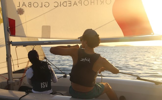 Antilles sailors competing on the water at sunset
